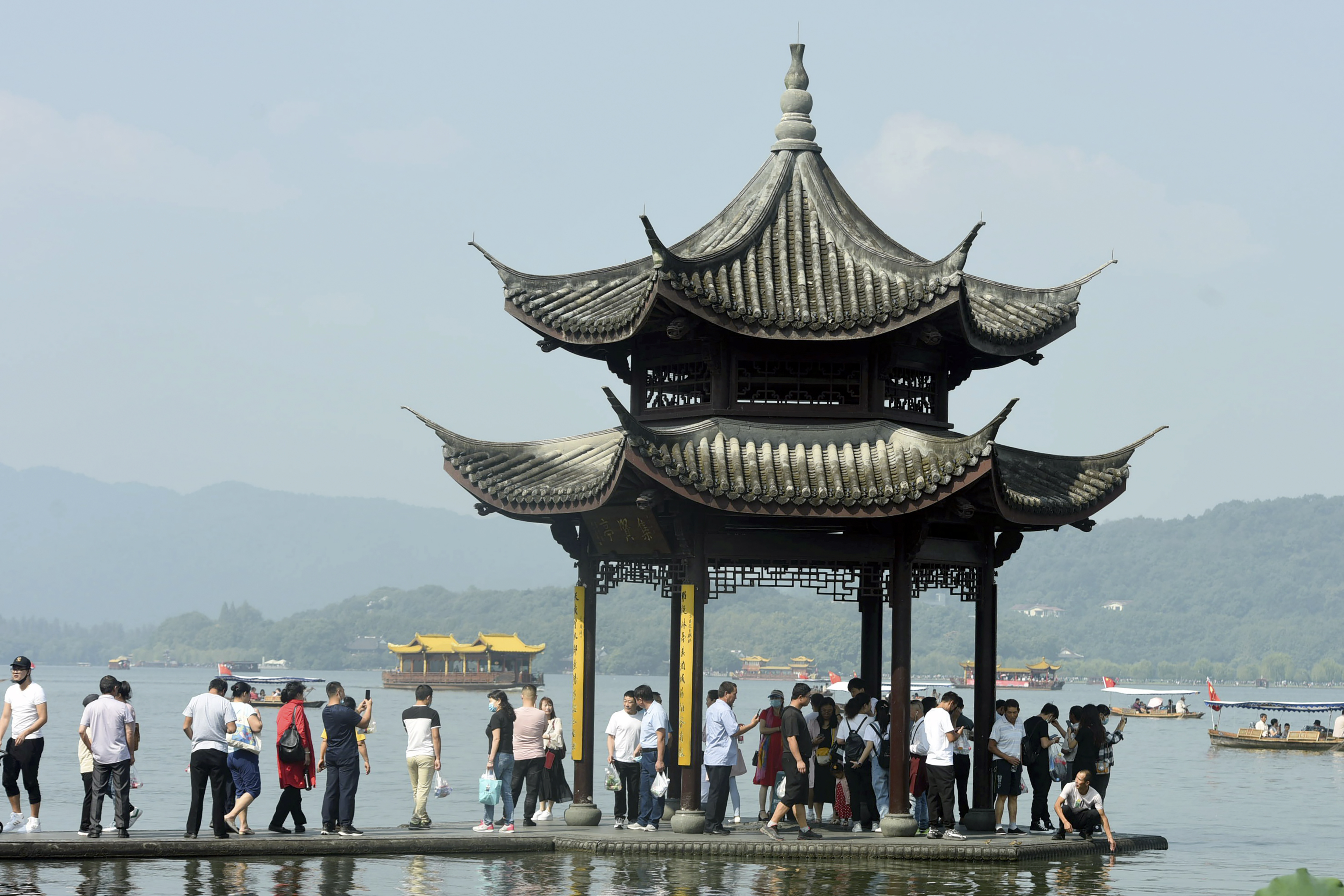 The Latest: Millions of Chinese travel locally for holidays
