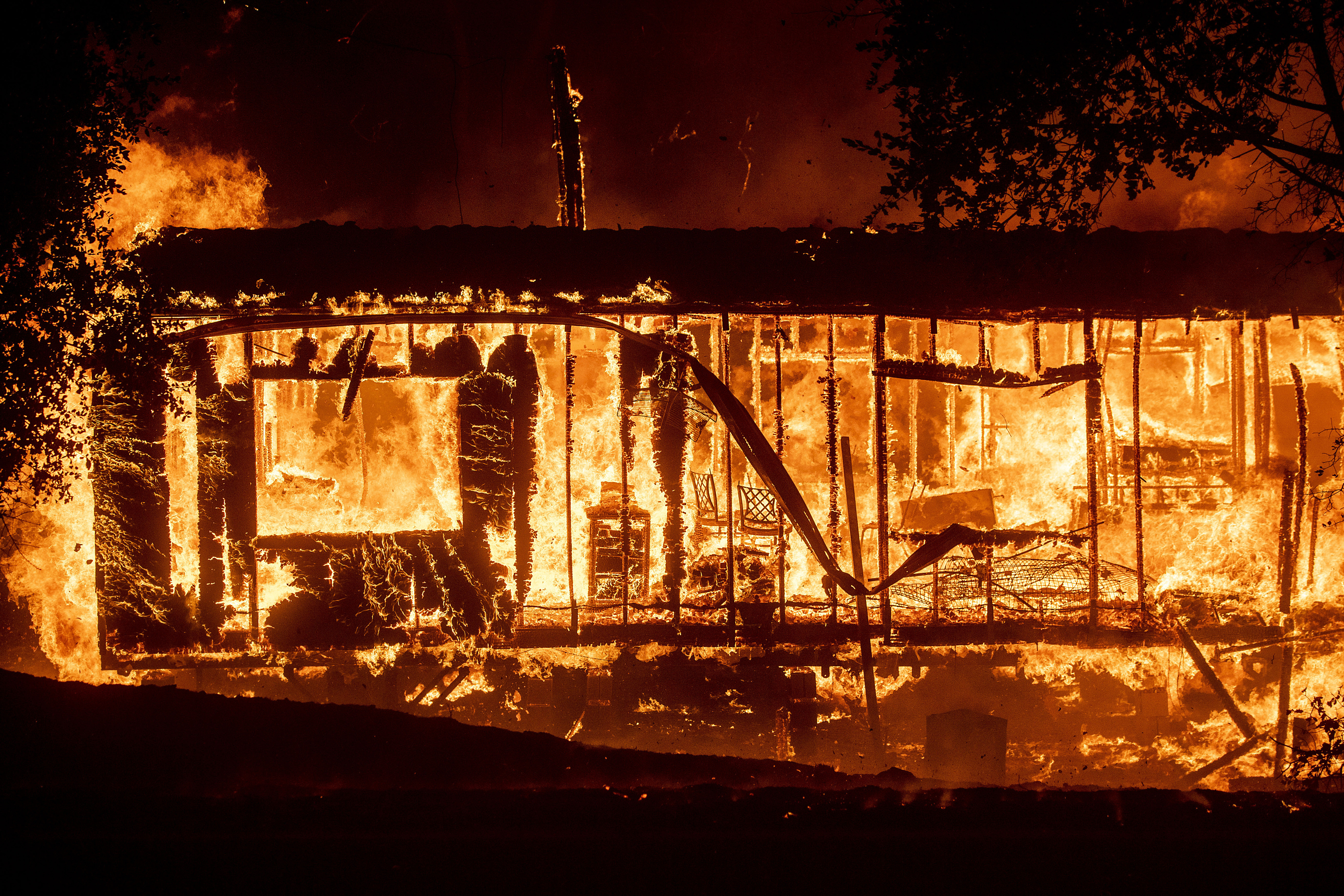 Wind-whipped fires rage across California as lights go dark